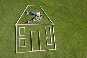 Zwei Menschen liegen im Gras in einem symbolischen Haus