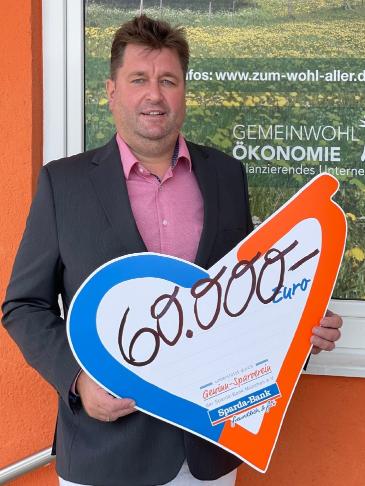 Michael Walch von der Sparda-Bank Filiale in Freilassing mit symbolischem Spendenscheck 